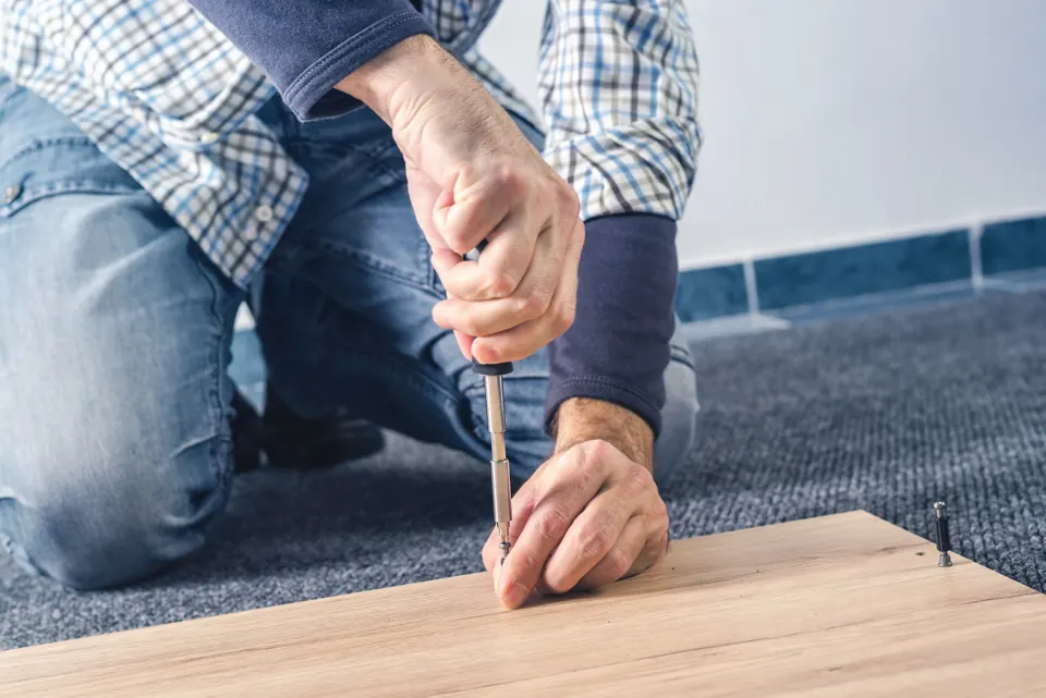 Man using a screwdriver on a board