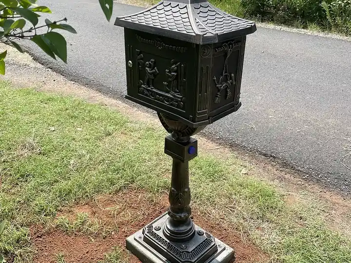 Locking mailbox on a pedestal post beside a driveway